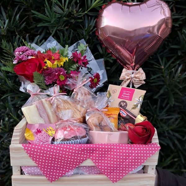 Cesta em caixote de madeira com flores, pães, cupcake, doces e balão de coração rosê — flores e café da manhã juntos.